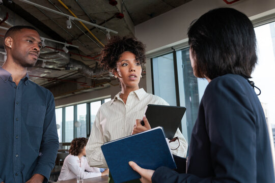 Business professionals discuss plans in a modern office setting.