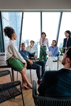 Woman presenting strategy during team meeting in office
