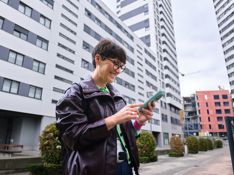 Smiling woman using smartphone in urban setting