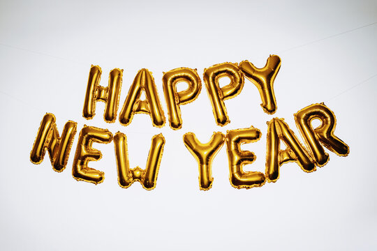 Gold happy new year balloons on white background