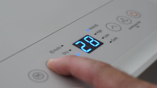Turning Down Temperature on Thermostat in Summer in Hot Weather. Setting Digital Home Thermostat to Cool and Programming Air Conditioner. Adjusting Room Temperature to Energy Saving in Summer Heat.