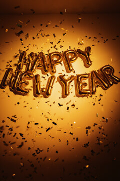 Gold happy new year balloons with confetti