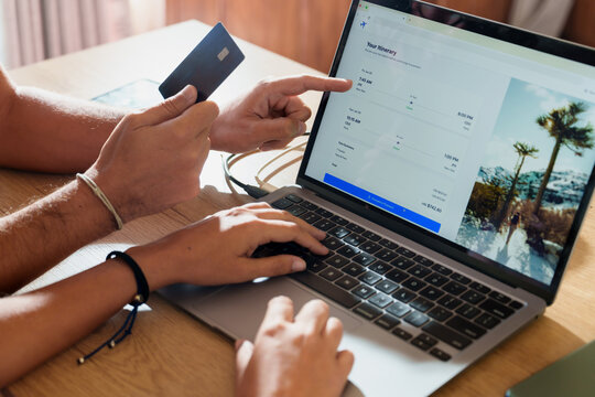 couple booking Flights Online with Credit Card on Laptop