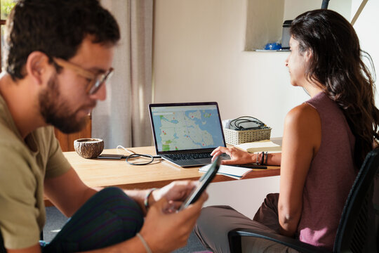 Couple Planning a Trip Together with Laptop and Phone
