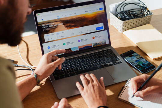 couple Searching Flights on Laptop with notebook on Desk