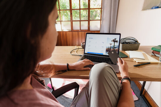 Woman Buying Flights Online with Credit Card on Laptop