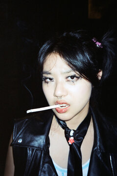 Young Woman Smoking a Cigarette in Leather Vest on Film