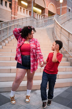 Mother and son sharing playful moment on urban stairs