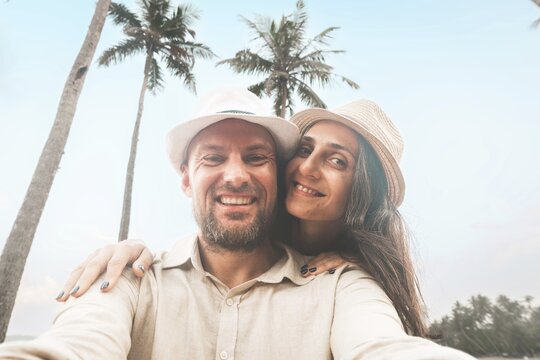 Young happy couple visit coconut island pose happy face taking holiday photo selfie in Sri lanka, Mirissa. People on holiday lifestyle concept
