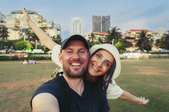 Cute happy caucasian couple enjoy travel freedom pose looking at camera explore Sri lanka city Colombo. Bonding and togetherness embracing time together