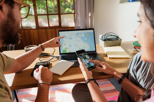 Couple Planning a Trip Together with Laptop and Phone