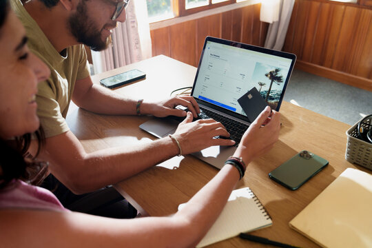 couple booking Flights Online with Credit Card on Laptop