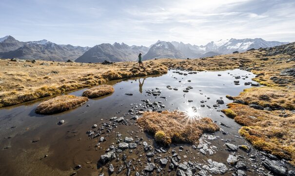 Mountaineers at a small lake on the high plateau of the Gurgler Seenplatte, glaciated mountain peaks in the background, in autumn, Sonnenstern, near Obergurgl, &Ouml;tztal Alps, Tyrol, Austria