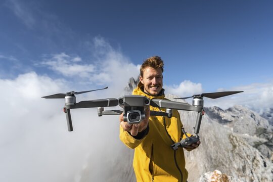 Young man holding a drone with camera, DJI Mavic Pro, summit western T&ouml;rlspitze, Wetterstein Mountains, Garmisch Partenkirchen, Bavaria, Germany