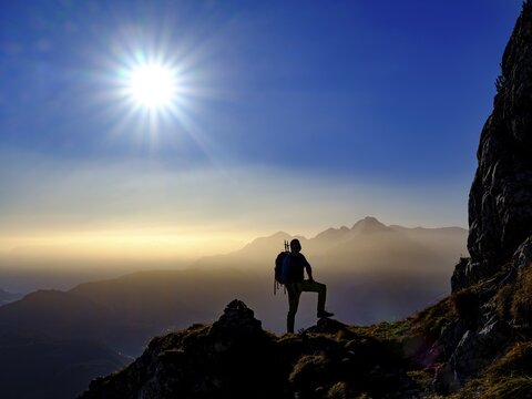 Silhouette of a mountaineer on an exposed path in the morning sun, in the background Hoher G&ouml;ll, Grubenpfad, Untersberg, Berchtesgadener Alpen, Marktschellenberg, Berchtesgadener Land, Upper Bavaria, Bavaria, Germany