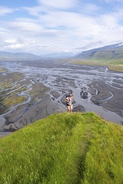 Hiker, Young woman on a hill, view over alluvial land, meandering river, D&iacute;monarhellir, Su&eth;urland, Iceland