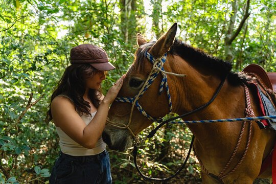 Woman bonding with horse in forest showing connection