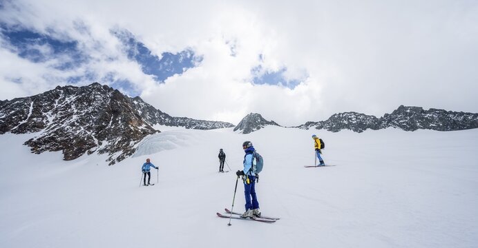 Group of ski tourers and splitboarders on the descent at Alpeiner Ferner, Stubai Alps, Tyrol, Austria
