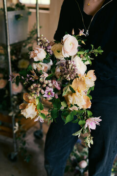 florist holding wedding spring flower bouquet in her hands