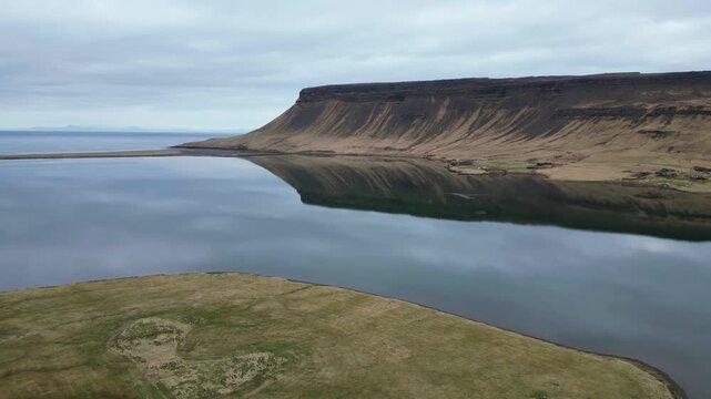 Survol d'une montagne plate au bord d'un lac en Islande