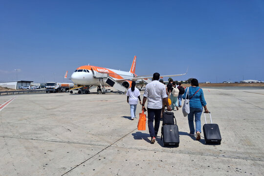 Larnaca, Cyprus - September 4 2025: Group of travelers heading towards an easyJet airplane to embark