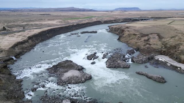 face &agrave; une large rivi&egrave;re et ses remous au milieu d'une plaine d&eacute;sertique d'Islande