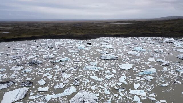 des centaines de morceaux de glace recouvrent les eaux marrons d'un lac glaciaire