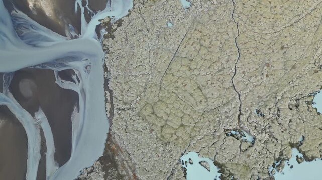Survol &agrave; la verticale des m&eacute;andres d'une rivi&egrave;re au milieu d'un champs de lave recouvert de lichen