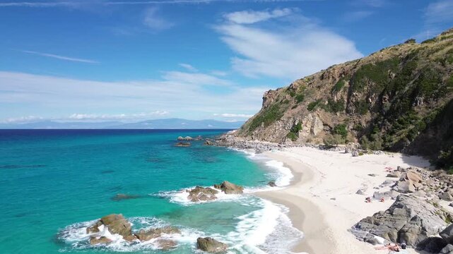Zambrone Beach on the Costa degli Dei in Calabria, Italy, aerial drone view of turquoise Tyrrhenian Sea, rocky coastline and white sandy beach on a sunny summer day.