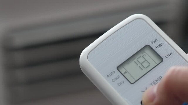 Turning Down Temperature on Thermostat in Summer in Hot Weather. Setting Digital Home Thermostat to Cool and Programming Air Conditioner. Adjusting Room Temperature to Energy Saving in Summer Heat.