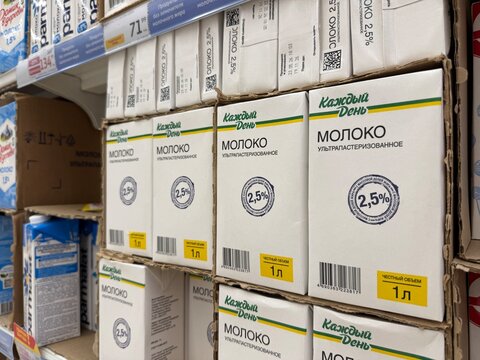 Khimki, Russia - June 25, 2026: Milk cartons displayed on a supermarket shelf featuring labels in Russian with nutritional information and brand names clearly visible