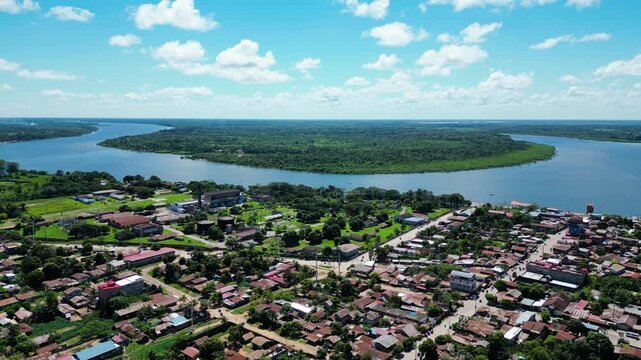 Cinematic aerial drone video of Yarinacocha town with the immense Ucayali River winding through the green Amazon horizon in the background.