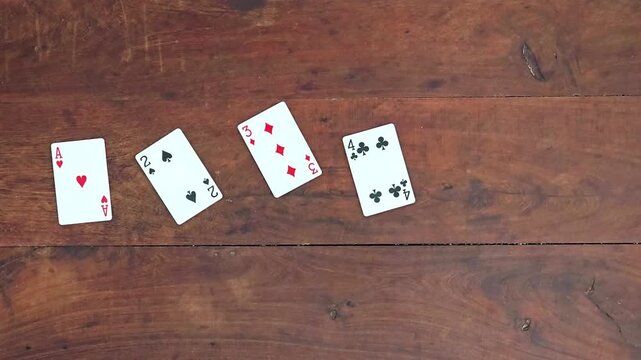 Cartas de p&oacute;ker apareciendo en orden num&eacute;rico sobre mesa de madera r&uacute;stica