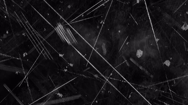 Abstract dark background with dynamic white scratch lines and light particles.