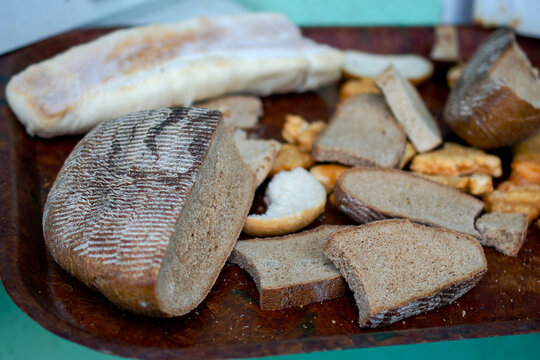 Food waste and hunger crisis, stale bread pieces on a tray, poverty and scarcity.