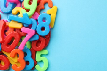 Fototapeta premium Different colorful numbers on light blue background, flat lay. Space for text