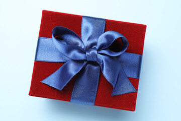 Fototapeta premium Beautiful velvet gift box on light blue background, top view