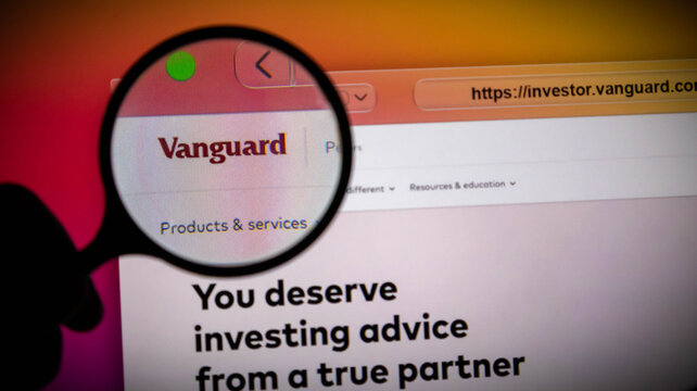 Closeup of a magnifying glass over the vanguard investment website on a computer screen