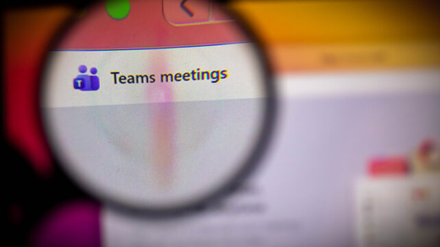 Closeup of a computer screen showing the microsoft teams meetings interface through a magnifying glass