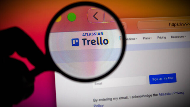 Closeup of a magnifying glass over the trello logo on a computer screen