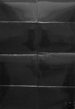 Black Glossy Paper Behind Laminating Film with Wrinkles and Fold Seams Texture