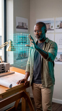 Confident Architect Reviewing Holographic Building Wireframe