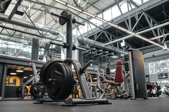 Gimnasio bien iluminado con una gran variedad de equipos para hacer ejercicio