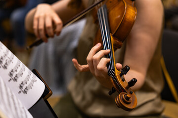 Close up of a musician playing violin during an orchestra performance © Ruslan