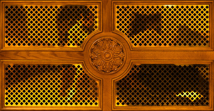Symmetrical shot of decorative wooden panel with carved rosette and lattice ornament