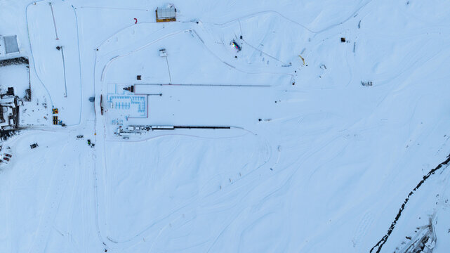 Aerial view of the snow-covered cross-country ski tracks and facilities in Cogne, surrounded by the pristine winter landscape of the Aosta Valley, Italy.