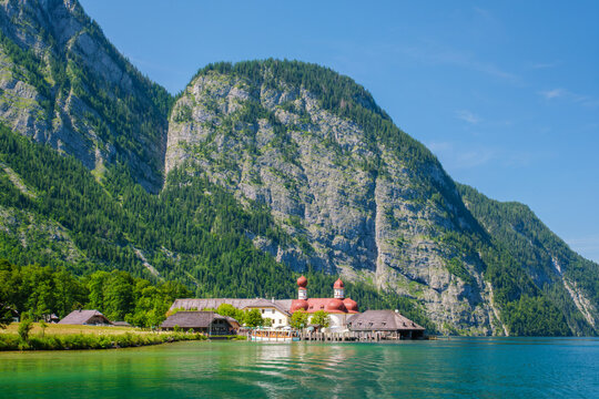 Scenic view of St. Bartholomew's Church with red onion domes on the shore of Konigsee lake surrounded by the Bavarian Alps, Berchtesgaden, Germany.