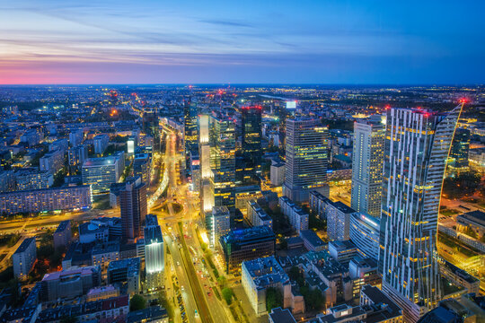 Cityscape view of the Warsaw skyline in Poland with skyscrapers, city lights, traffic trails, blue hour twilight and evening glow