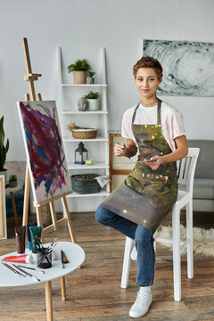 In a charming home studio, a young woman with short hair passionately creates her latest artwork.