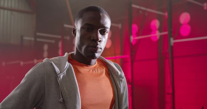 African American man standing hands on hips at gym as camera closing in showing lights promo